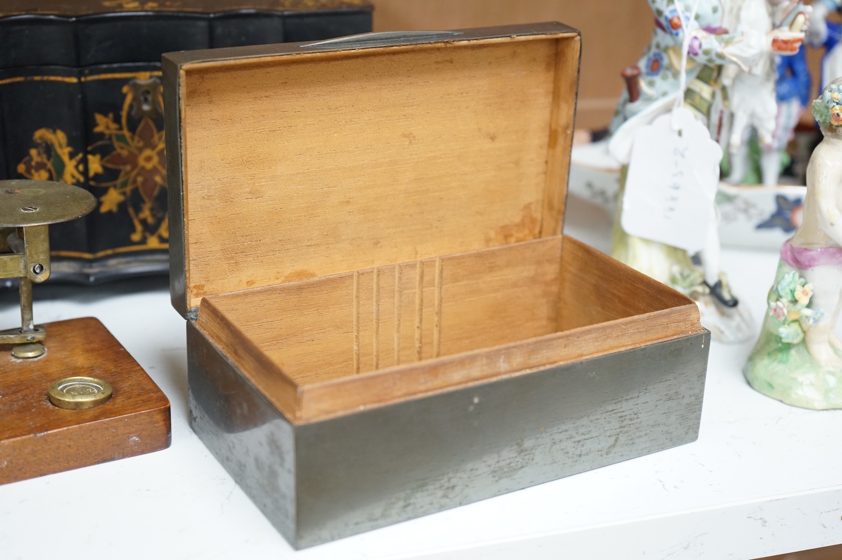 A Victorian papier maché tea caddy, postal scales and a military interest cigarette box, largest 19cm wide